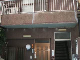 集合住宅出入口上部の外壁のヒビ割れ補修工事（施工前）
